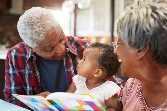 Grandparents with Young Child and Book